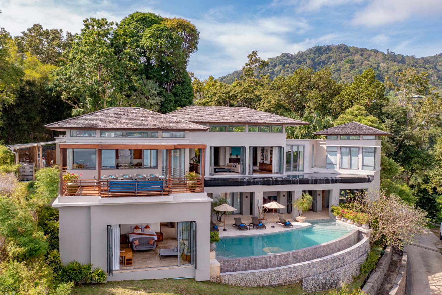 Aerial view of a luxury villa and its pool above the Phuket coast, managed by Shibumi Services